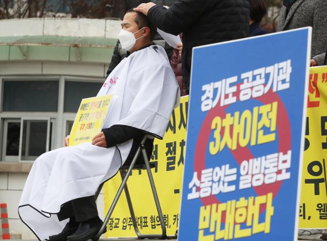 25일 수원 광교 주민이 도청 앞에서 경기도 공공기관 3차 이전에 반대하며 삭발 시위를 벌이고 있다. 연합뉴스