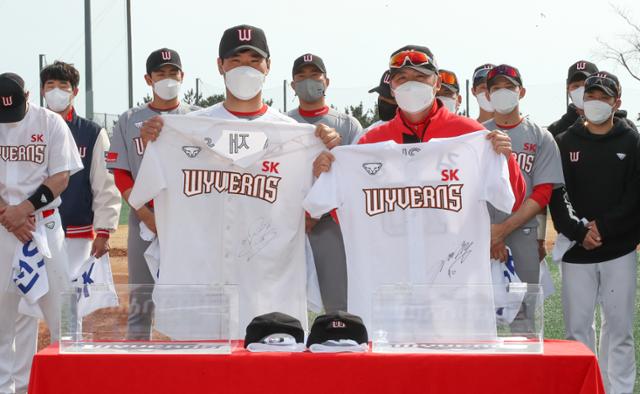 신세계그룹 이마트에 매각된 KBO 프로야구팀 SK 와이번스 선수단이 5일 오후 제주 서귀포시 강창학야구장에서 스프링캠프 마지막 훈련을 소화한 뒤 유니폼을 반납하는 세리모니를 하고 있다. 주장 이재원(앞줄 왼쪽)과 김원형 감독이 SK유니폼을 들고 기념촬영하고 있다. 뉴시스