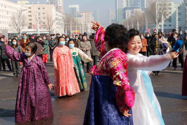 북한 여성들이 지난 8일 '세계 여성의 날'을 맞아 평양대극장 앞에서 춤을 추고 있다. AP 연합뉴스