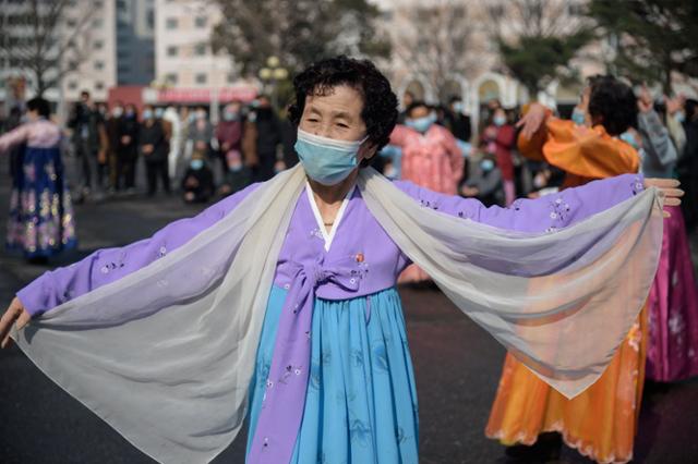 북한 여성들이 지난 8일 '세계 여성의 날'을 맞아 평양대극장 앞에서 춤을 추고 있다. AFP 연합뉴스