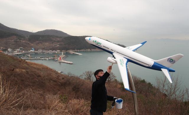 4일 오전 부산 강서구 대항동 대항전망대에서 한 페인트 작업자가 비행기 모형에 적힌 신공항 건설 반대 문구를 지우는 페인트 작업을 하고 있다. 부산=뉴스1