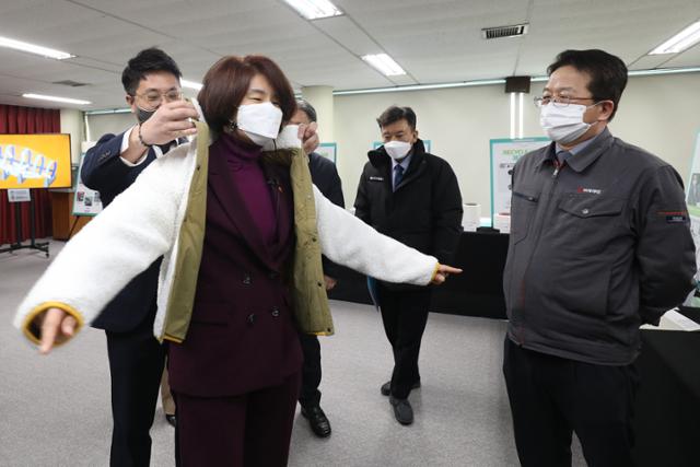 한정애 환경부 장관이 지난달 4일 경북 칠곡군 석적읍 티케이케미칼 폴리에스터 공장을 방문해 페트병 재활용 공정에 대한 설명을 들은 뒤 재활용 과정을 거쳐 생산된 의류를 입어보고 있다. 칠곡=뉴스1