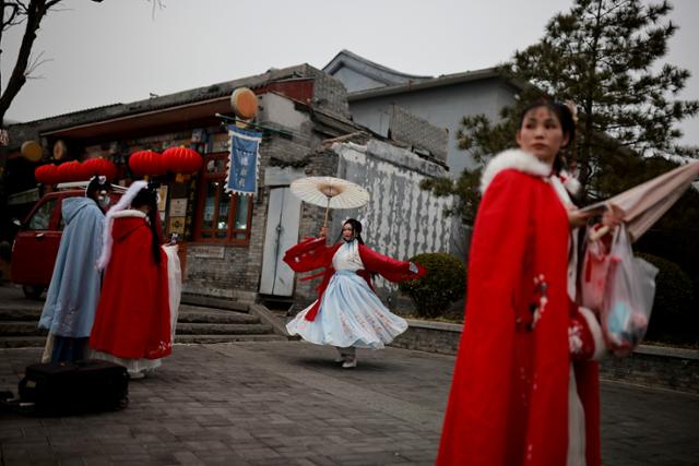 한푸를 차려 입은 중국 여성들이 춘제(우리의 설) 연휴기간인 지난달 14일 옛 정취가 묻어나는 베이징의 거리를 거닐고 있다. 베이징=로이터 연합뉴스