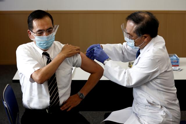 지난달 17일 일본 도쿄의료센터의 아라키 가즈히로(왼쪽) 원장이 일본 최초로 화이자 백신을 접종받고 있다. 도쿄=로이터 연합뉴스