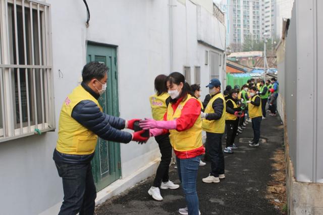 사랑 더하기 나눔봉사단과 탈북민 한부모가족봉사단이 21일 대전 동구 용운동에서 형편이 어려운 소외이웃에게 '사랑의 연탄'을 전달하고 있다.