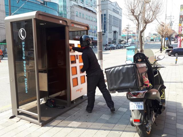 전기 오토바이 운전자가 공중전화 부스를 활용한 '전기 이륜차 배터리 교환 시설'에서 전기 배터리를 갈아끼우고 있다. 엠비아이 제공