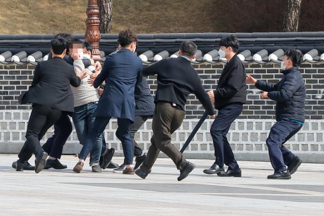 24일 오전 국립 5·18 민주묘지에서 국민의힘 김종인 비상대책위원장의 참배에 대학생이 항의하려다 제지당하고 있다. 연합뉴스