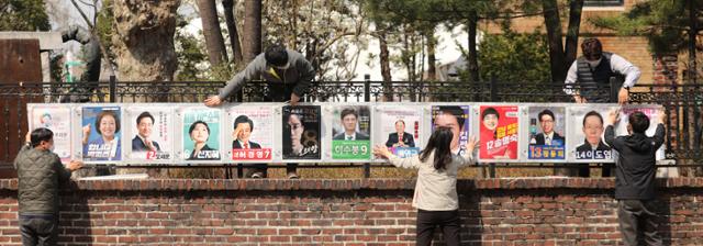 서울특별시선거관리위원회 직원들이 25일 서울 종로구 이화동 예술가의집 울타리에 '4·7 서울시장 보궐선거'에 출마하는 후보자들의 선거벽보를 붙이고 있다. 이번 선거에는 박영선·오세훈 후보 외에도 10명이 출마했지만 존재감은 미미하다. 배우한 기자