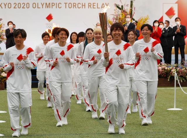 동일본대지진이 발생했던 2011년 축구 여자 월드컵 독일대회에서 우승한 일본 대표팀 '나데시코 재팬'의 멤버들이 25일 도쿄 동북부 후쿠시마현에서 도쿄 올림픽 성화 봉송의 첫 주자로 나서고 있다. 성화 봉송은 도쿄올림픽 개막식이 열리는 7월 23일까지 121일 동안 진행된다. 약 1만 명의 봉송 주자가 일본 47개 도도부현(都道府縣·광역자치단체) 전역을 달릴 예정이다. 나하라 AP=연합뉴스