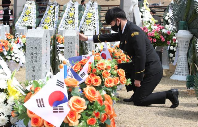 서해수호의 날인 26일 오전 대전 유성구 국립대전현충원 천안함 46용사 묘역을 찾은 대덕대 군사학과 학생이 참배한 뒤 묘역을 만지고 있다. 뉴스1