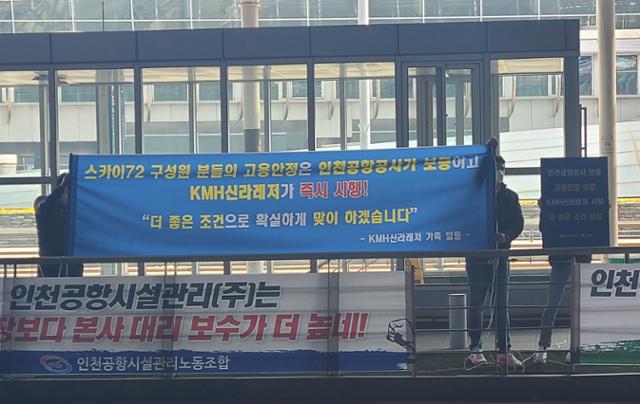 인천국제공항 골프장 새 사업자인 KMH신라레저 관계자들이 지난 25일 인천공항 제1여객터미널 앞에서 골프장 노동자 고용 승계를 약속하는 현수막을 펼치고 있다. 독자 제공