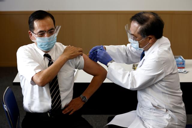 일본 정부는 복수의 신종 코로나바이러스 감염증(코로나19) 백신이 승인될 경우 국민이 선택할 수 있도록 할 전망이다. 사진은 지난달 17일 도쿄 메구로구 소재 국립병원 도쿄의료센터에서 일본의 첫 코로나19 백신 접종자인 아라키 가즈히로 원장이 접종하는 모습. 도쿄=AP 뉴시스