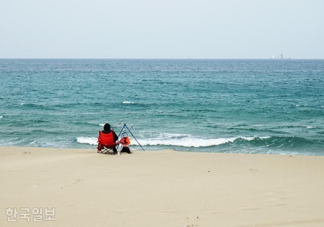 덕산해변은 맹방해변보다 상대적으로 한산하다. 낚시꾼이 나 홀로 낚싯대를 드리우고 있다.