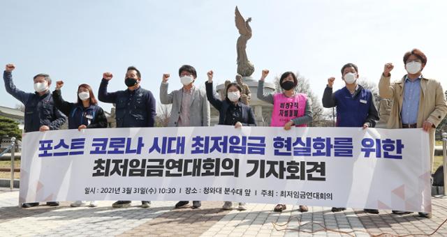 민주노총, 한국노총이 참여한 '최저임금연대' 관계자들이 31일 청와대 분수대 앞에서 '포스트 코로나 시대 최저임금 현실화를 위한 기자회견'을 열고 최저임금 인상을 요구하는 구호를 외치고 있다. 연합뉴스