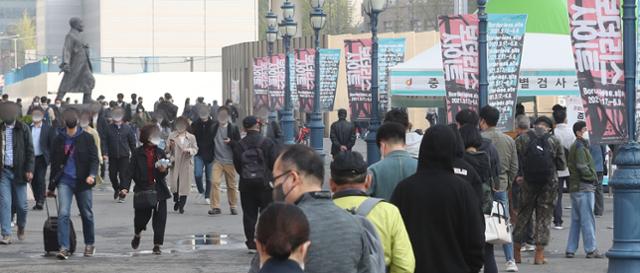 신종 코로나바이러스 감염증(코로나19) 신규 확진자가 668명으로 집계되면서 89일 만에 최다를 기록한 7일 서울역을 찾은 인파 옆으로 시민들이 코로나19 검사를 하기 위해 대기하고 있다. 뉴스1