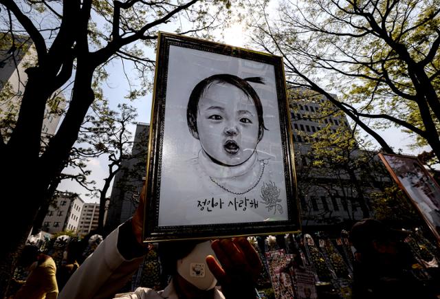 16개월 된 입양 딸 정인 양을 학대해 숨지게 한 혐의를 받는 양부모의 공판이 열린 지난 7일 오후 서울 양천구 서울남부지방법원 입구에서 시민이 정인 양의 초상화를 들고 양부모의 엄벌을 촉구하고 있다. 연합뉴스