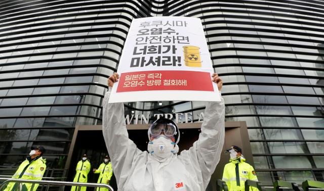 16일 오후 서울 종로구 주한일본대사관 앞에서 서울민중행동과 615공동선언실천 남측위원회 서울본부 공동 주최로 열린 일본 정부의 후쿠시마 원전 오염수 해양 방류 규탄 기자회견에서 한 참가자가 방호복을 입고 피케팅 퍼포먼스를 하고 있다. 뉴시스