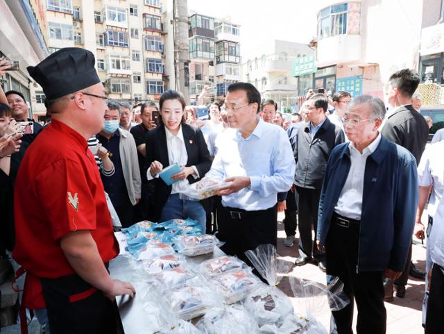 리커창(오른쪽 두 번째) 중국 총리가 지난해 6월 산둥성 옌타이의 구시가지를 시찰하면서 노점 상인과 대화하고 있다. 옌타이=신화 뉴시스