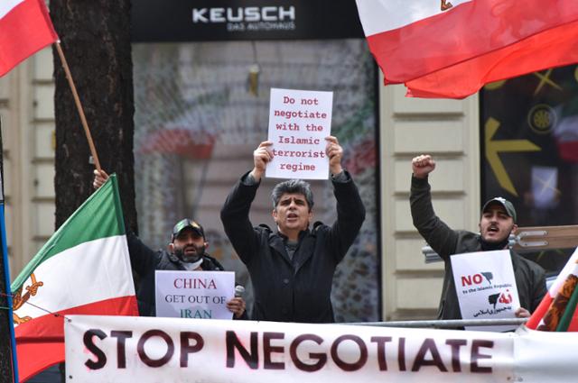 '이란 핵합의'(JCPOA·포괄적공동행동계획) 복원을 위한 협상이 진행되고 있는 오스트리아 빈의 그랜드호텔 앞에서 20일 이란 야권인 국가저항평의회 회원들이 '협상을 중단하라'라고 쓰인 플래카드를 들고 시위를 벌이고 있다. 빈=AFP 연합뉴스