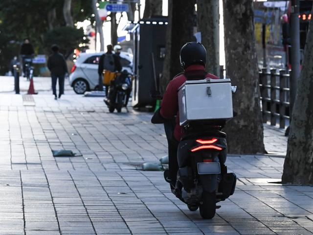 신종 코로나바이러스 감염증(코로나19) 사태로 배달 대행 수요가 폭발적으로 늘면서 오토바이 운전자의 교통사고와 법규 위반 행위가 급증하고 있다. 사진은 서울 강남구 한 인도를 달리는 배달 오토바이 모습. 이한호 기자