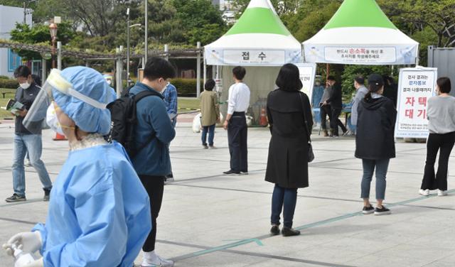 대구 지역 코로나19 확진자가 12명으로 집계된 27일 대구 중구 국채보상운동기념공원에 마련된 임시선별검사소에서 시민들이 검사를 받기 위해 줄 서 기다리고 있다. 뉴시스