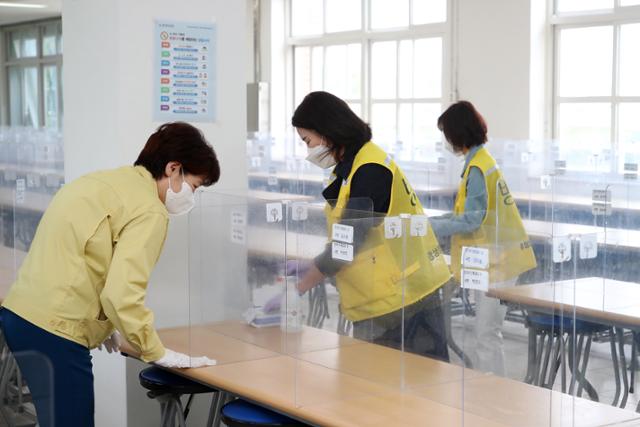 29일 대구 남구 경상공고 학생급식실에서 강은희 대구시교육감과 학교전담 방역요원이 점심시간을 앞두고 칸막이 등 식사 공간을 소독하고 있다. 뉴스1