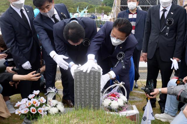 5·18 민주화운동 제41주년을 하루 앞둔 17일 광주 북구 국립5·18 민주묘지에서 열린 5·18 민중항쟁 제41주년 추모제에 정운천·성일종 국민의힘 의원이 고 전재수군의 묘역을 어루어 만지고 있다. 보수정당 소속 의원들이 5·18 민주유공자유족회로부터 공식 초청을 받아 추모제에 참석한 것은 이번이 처음이다. 뉴스1