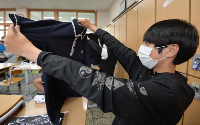 중학교 무상 교복 배부 행사가 열린 20일 대구 서구 평리중학교 교실에서 학생들이 배부 받은 교복을 살펴보고 있다. 대구=뉴시스