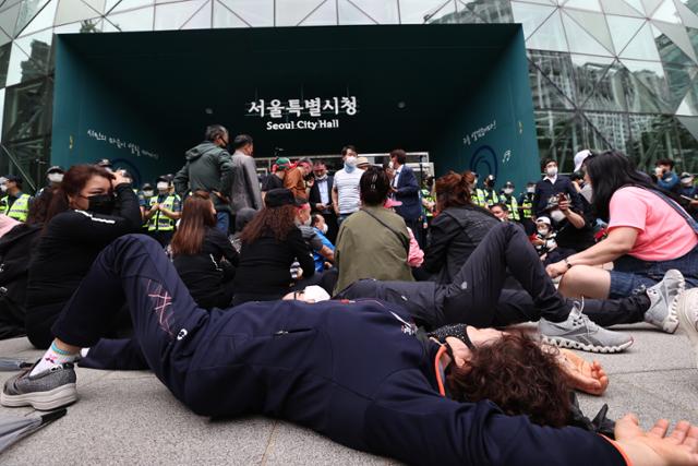 20일 오후 한국유흥음식업중앙회·한국단란주점업중앙회·한국콜라텍협회 관계자 및 업주들이 정부에 집합금지 해제 및 손실보상법 통과를 촉구하며 서울 중구 서울시청 내부로 진입하던 중 경찰에 막히자 농성을 벌이고 있다. 연합뉴스