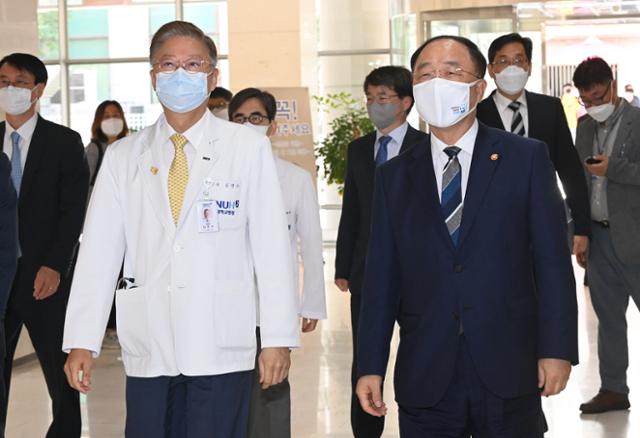 홍남기(오른쪽) 부총리 겸 기획재정부 장관이 26일 오전 서울 종로구 서울대학교병원 의료기기혁신센터에서 열린 혁신성장 BIG3 추진회의에 참석하고 있다. 왼쪽은 김연수 서울대학교병원장. 연합뉴스