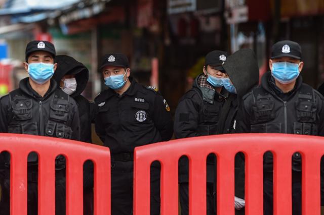 지난해 1월 중국 우한 화난 수산시장 입구를 중국 공안과 경비원들이 지키고 있다. 우한=AFP 연합뉴스