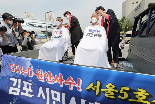 더불어민주당 김주영(김포시갑) 의원과 박상혁(김포시을) 의원이 2일 오후 세종시 정부세종청사 국토교통부 앞에서 '수도권광역급행철도(GTX-D) 김포-하남 노선 반영과 서울지하철 5호선 김포 연장'을 촉구하며 삭발을 하고 있다. 세종=연합뉴스