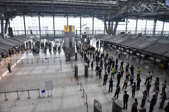 4월 태국 수도 방콕 외곽의 수완나품 국제공항에서 공항 직원들이 중국 시노백사의 코로나19 백신을 맞기 위해 줄지어 차례를 기다리고 있다. 방콕=AFP 연합뉴스