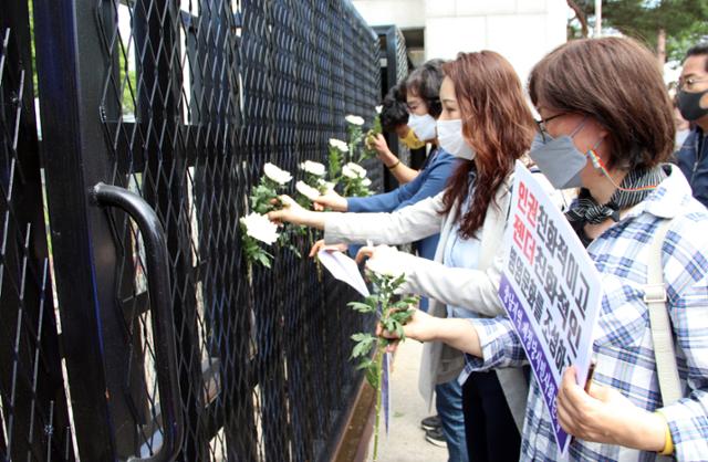 정의당 충남도당과 충남지역 50여 개 시민단체 회원들이 4일 공군 여성 부사관 성추행 피해자 사망사건이 발생한 서산 공군 20전투비행단 앞에서 철저한 수사를 촉구하는 기자회견을 한 뒤 고인을 애도하는 뜻으로 정문에 국화를 꽂고 있다. 서산=연합뉴스