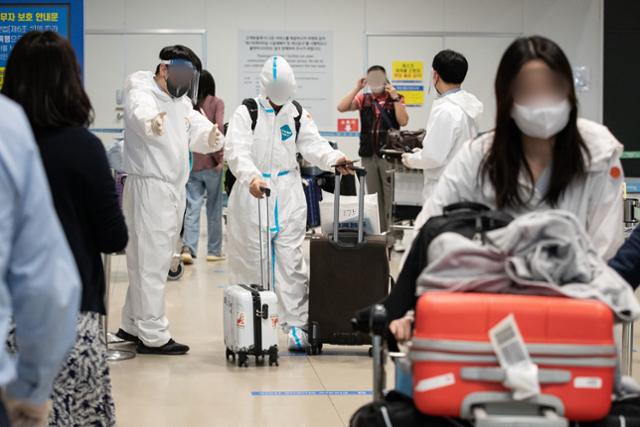 인천국제공항 검역소 관련 신종 코로나바이러스 감염증(코로나19) 확진자 15명이 인도발 변이 바이러스 감염으로 확인된 가운데 20일 인천국제공항 제1여객터미널 입국장에서 방역관계자들이 입국자들을 안내하고 있다. 뉴스1