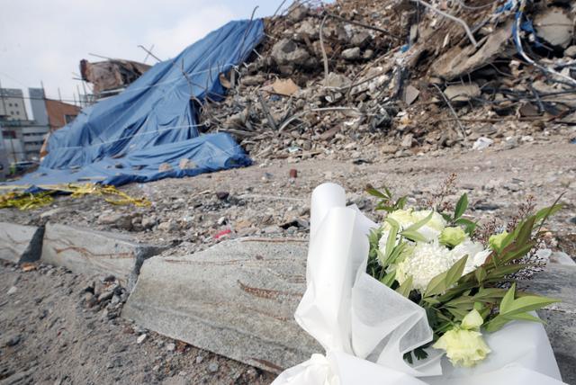 13일 오전 광주광역시 철거 건물 붕괴 참사 현장 도로에 사망자를 추모하는 꽃다발과 손편지가 놓여 있다. 연합뉴스