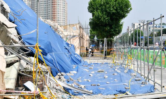 공사 관계자들이 14일 오전 광주 동구 학동 철거 건물 붕괴 참사 현장에서 안전 펜스를 설치하고 있다. 연합뉴스