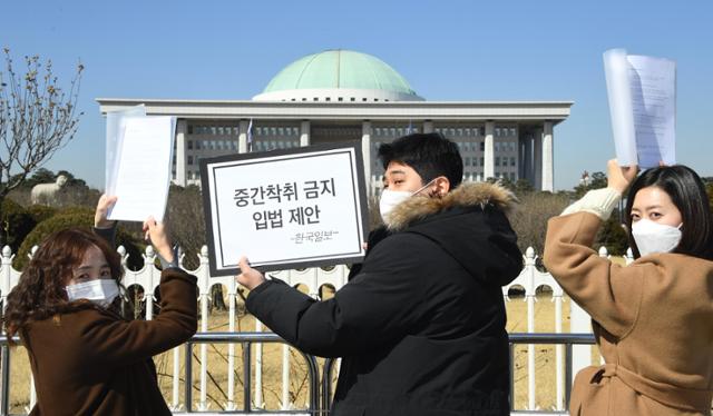 지난 2월 24일 국회 정문에서 한국일보 마이너리티팀 취재진이 국회의원들에게 전달할 '중간착취 근절을 위한 입법관련 질의서'를 들어들어 보이고 있다. 오대근 기자