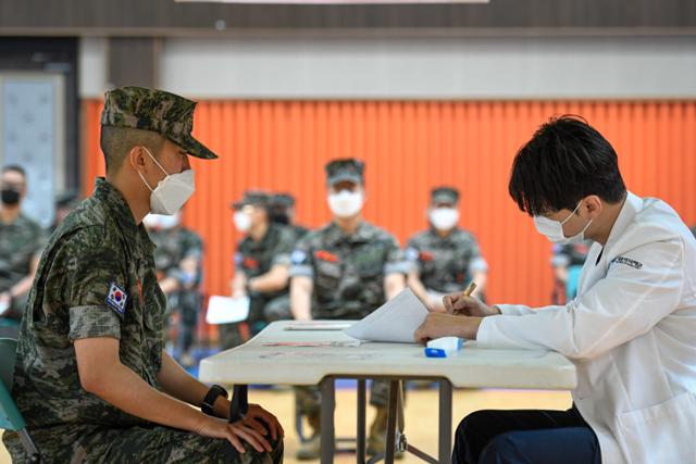 30세 미만 장병에 대한 코로나19 백신 접종이 시작된 7일 오전 해병대 사령부 실내체육관에서 한 장병이 백신 접종 전 문진을 받고 있다. 사진은 기사와 직접 관련없음. 국방부 제공