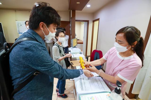 민방위 대원인 이준석 국민의힘 대표가 15일 오전 서울 노원구의 한 병원에서 신종 코로나바이러스 감염증(코로나19) 백신(얀센) 접종에 앞서 체온측정을 하고 있다. 뉴스1