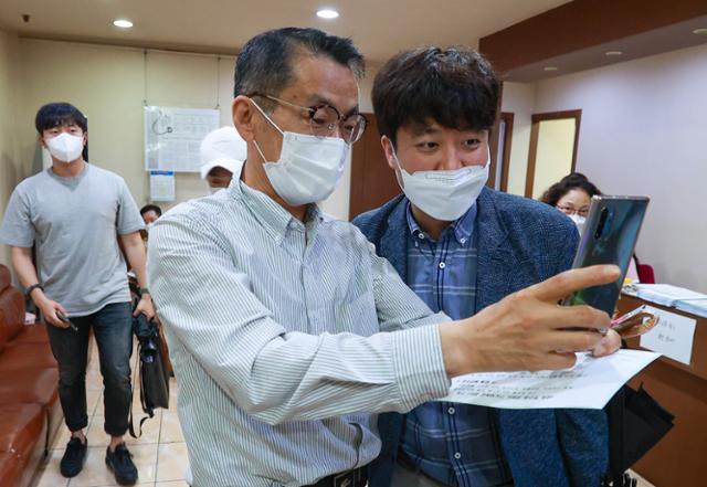 민방위 대원인 이준석 국민의힘 대표가 15일 오전 서울 노원구의 한 병원에서 신종 코로나바이러스 감염증(코로나19) 백신(얀센) 접종을 마친 뒤 시민들의 요청으로 기념사진을 찍고 있다. 뉴스1