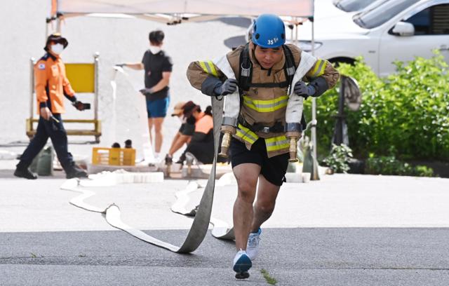 16일 오전 경기도 용인시 처인구 경기도소방학교에서 열린 '2021년 경기도 소방기술 경연대회'에서 최강소방관경기 참가자가 소방호스를 끌고 힘차게 달리고 있다. 용인=뉴시스