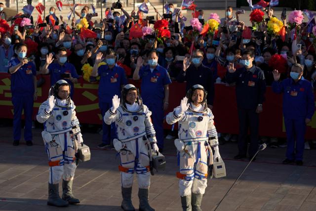 17일 중국 북서부 간쑤성 주취안 위성발사센터에서 창정-2F 야오-12 로켓에 실려 발사될 유인우주선 '선저우 12호'에 탑승할 우주인 세 명 (왼쪽부터) 탕훙보, 류보밍, 녜하이성이 출발하기 전 손을 흔들며 인사하고 있다. 중국은 이날 독자 우주정거장 건설 프로젝트의 일환으로 선저우 12호를 발사한다. 주취안 AP=연합뉴스