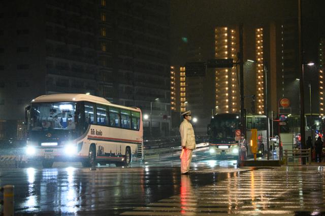 지난 20일 밤 도쿄올림픽 선수촌에서 여러 대의 버스가 출발하고 있다. 올림픽 개막식과 폐막식 때 선수들을 실어나르는 시뮬레이션이다. 도쿄=AP 연합뉴스