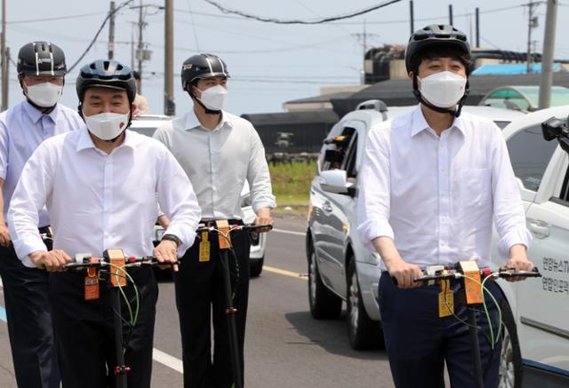 원희룡(왼쪽) 제주지사가 23일 이준석(오른쪽) 국민의힘 대표와 함께 전동킥보드를 타고 제주 구좌읍 해안도로를 달리고 있다. 제주=뉴스1