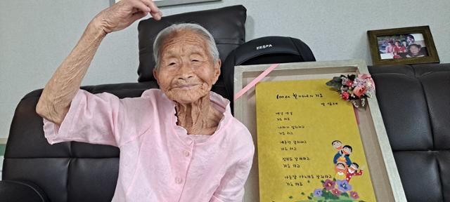 국내 최고령 구술 시인 백성례 할머니가 25일 전북 완주군청을 방문, 박성일 완주군수에게 선물한 '100세 할머니의 기도'라는 제목의 자작시 액자를 옆에두고 포즈를 취하고 있다. 완주군 제공