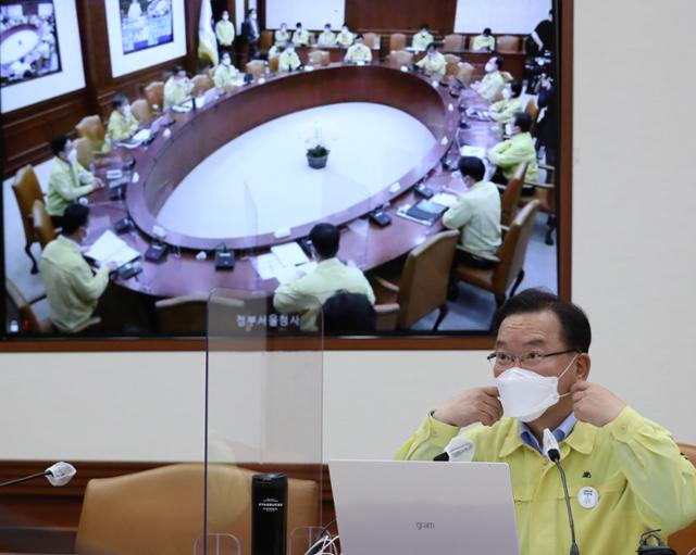 김부겸 국무총리가 27일 오후 서울 종로구 정부서울청사에서 열린 신종 코로나바이러스 감염증(코로나19) 대응 중앙재난안전대책본부(중대본) 회의에서 '사회적 거리 두기' 발언에 앞서 마스크를 벗고 있다. 공동취재사진