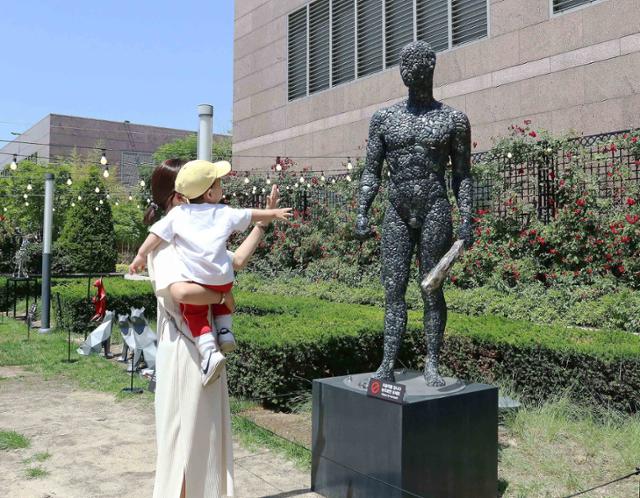 한 고객이 자녀와 함께 신세계백화점 강남점 옥상정원에 전시된 신채훈 작가의 작품을 감상하고 있다. 신세계백화점 제공