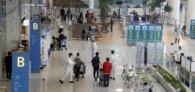 인천국제공항 입국장에서 입국자들이 방역 관계자들의 안내를 받고 있다. 인천=뉴스1