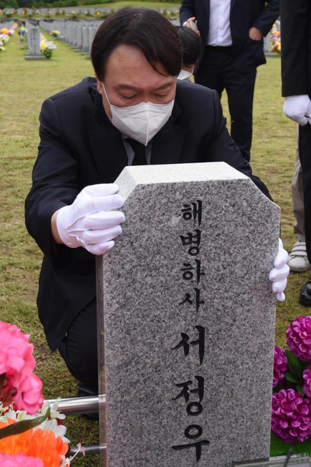 윤석열 전 검찰총장이 6일 오전 대전 유성구 국립대전현충원에서 연평해역 전사자 묘역을 찾아 서정우 하사의 묘비를 만지며 넋을 기리고 있다. 공동취재사진